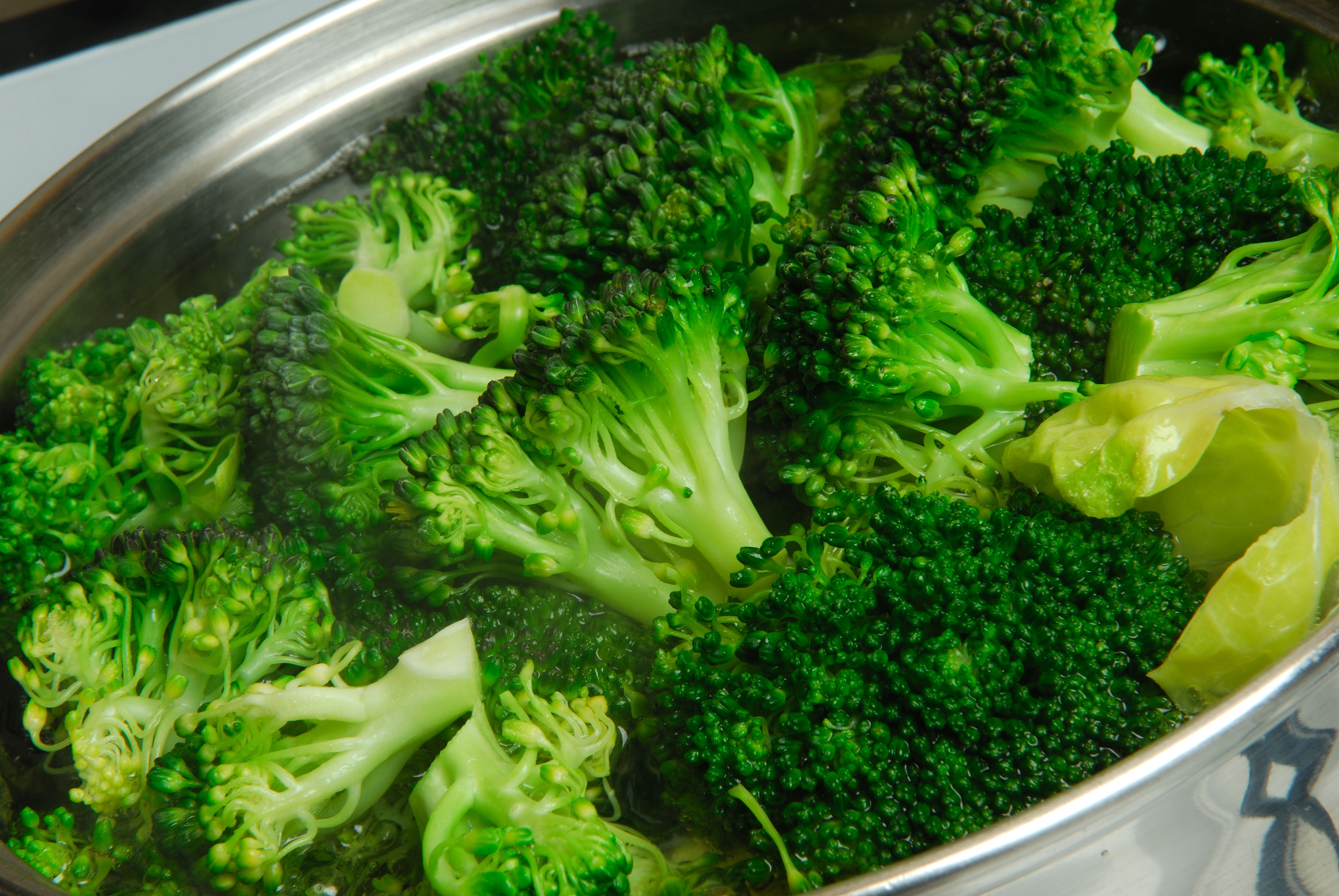 Broccoli cooking in saucepan.
