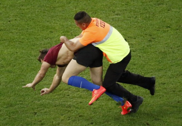 Security guard grabs a fan who ran onto the pitch during the 2014 World Cup final between Germany and Argentina at the Maracana stadium