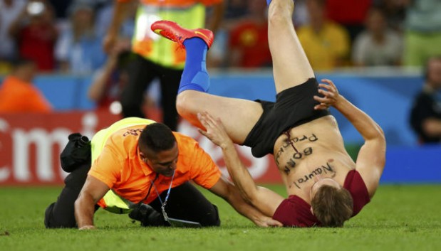 A pitch invader is tackled by a steward during the 2014 World Cup final between Argentina and Germany at the Maracana stadium in Rio de Janeiro