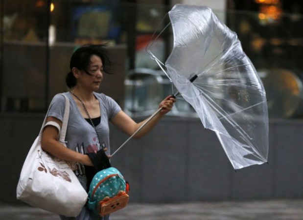 A woman struggles with an umbrella in strong winds and rain caused by Typhoon Halong in Tokyo